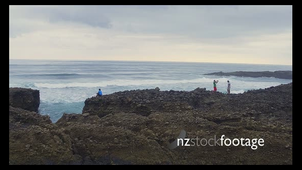 aerial of people fishing off rocks at karekare beach, Auckland, New Zealand 26704
